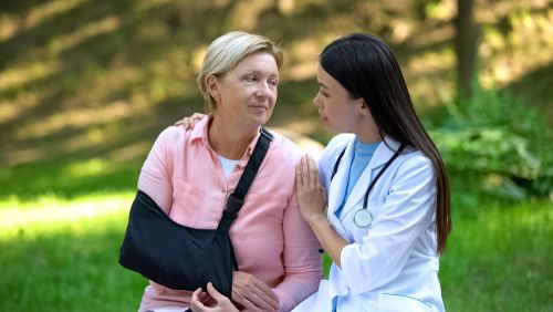 Care professional supporting a patient recovering after shoulder surgery