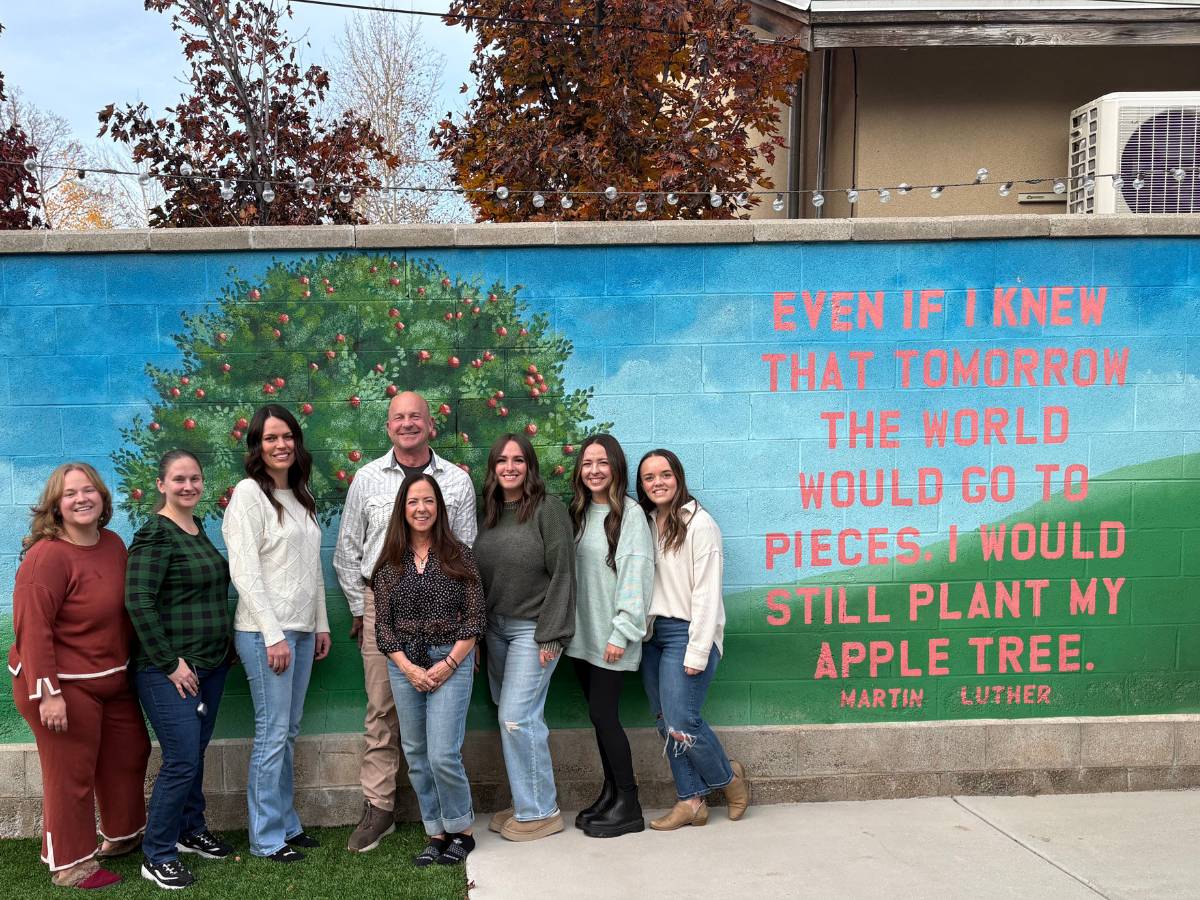 The Interim Home Care team standing in front of a mural in Utah.